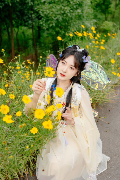 一个穿着中国服装的亚洲美女，正在室外花丛中图片下载