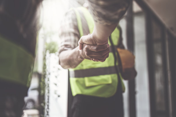 建筑师和工程施工工人在办公室施工现场完成协议后握手，成功的合作理念图片下载