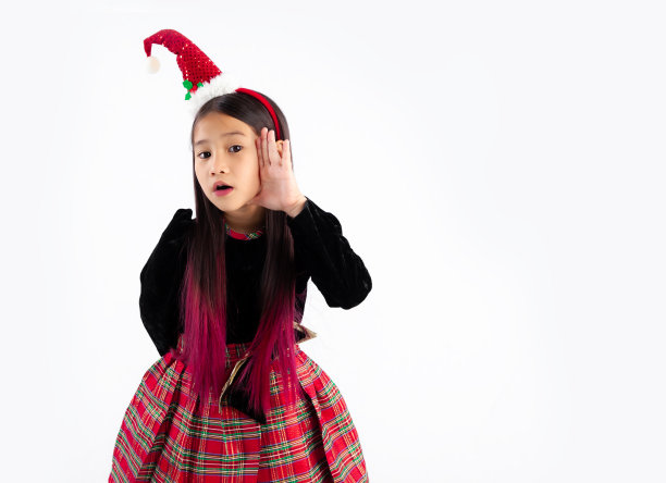 可爱的亚洲小孩女孩在圣诞节他们的服装，戴着圣诞老人帽子发带，在白色背景上摆姿势复制空间。圣诞快乐。图片下载