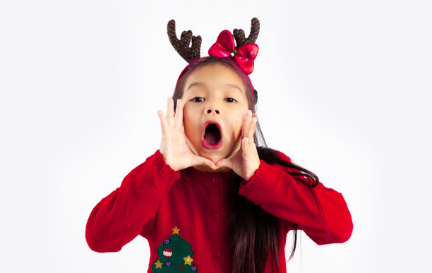 小亚洲孩子在红色运动衫圣诞主题服装摆着喊叫白色背景。图片下载