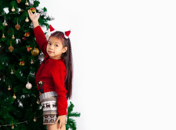 小女孩长发型在红色毛衣装饰圣诞树在家里白色的背景。图片下载