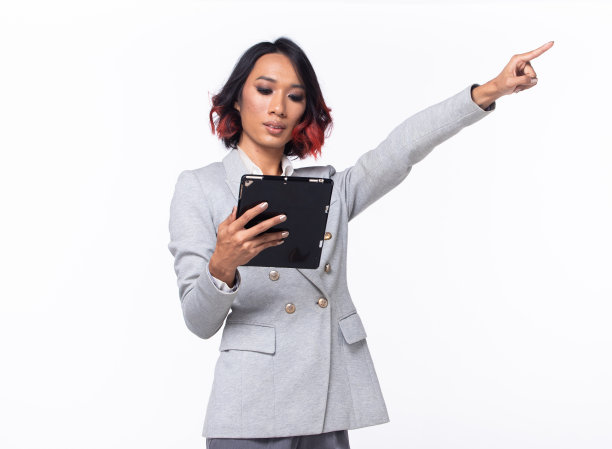 半身晒黑皮肤的亚洲印度女性指着天空，商业Blazer女性自信聪明地拿着平板电脑到未来的空区空气，工作室白色背景隔离图片下载