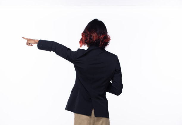 半身晒黑皮肤的亚洲印度女性手指指向天空，商务西装女性转身后背侧抱着平板电脑向未来空区空气，工作室白色背景隔离图片下载