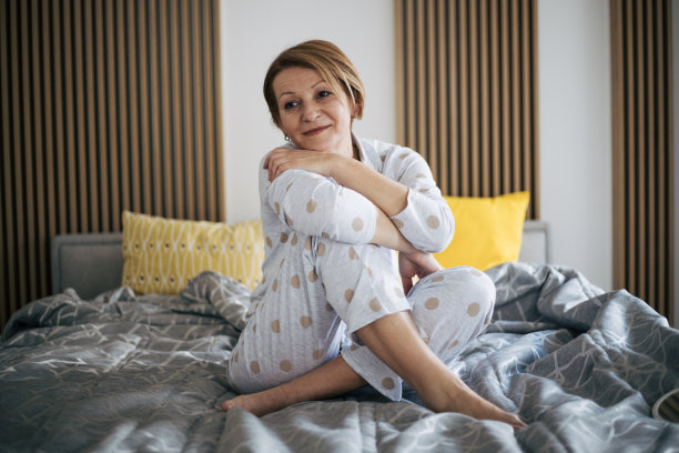 高级妇女在床上。图片下载