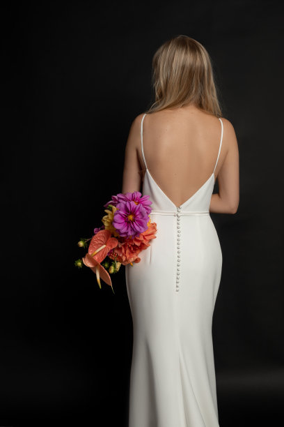 垂直后视图的金发女人长头发在白色纽扣连衣裙举行一束彩色的花在黑色工作室图片下载