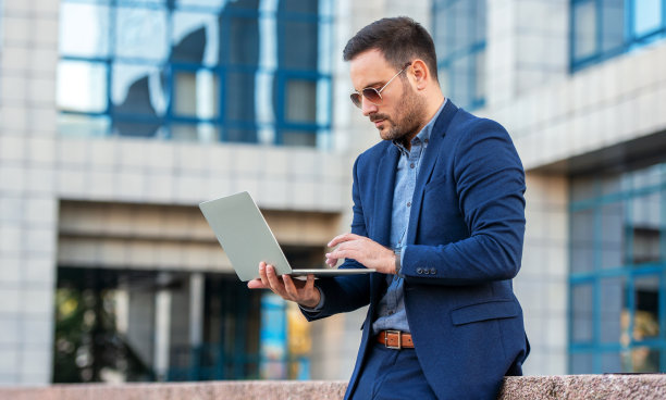 业务人员。商人在办公室前通过笔记本电脑检查数据。商业、生活方式概念图片下载