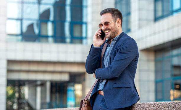 一个商人在公司前面打电话。商业、生活方式概念图片下载