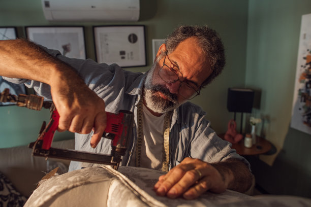 一位老人在家把扶手椅重新装好图片下载