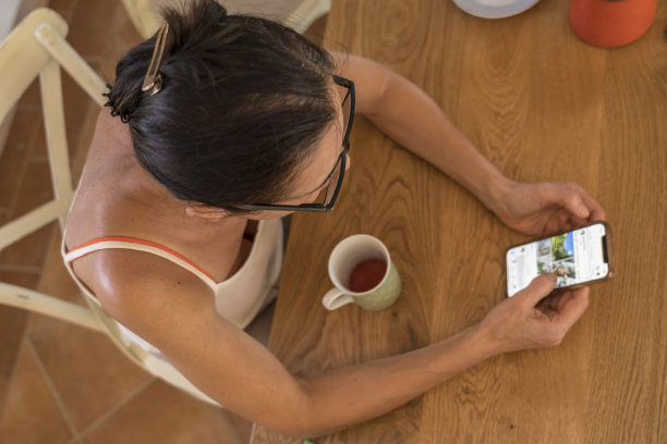 女人坐在厨房里拿着手机图片下载