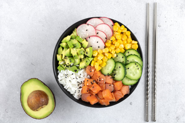 戳碗与鲑鱼，大米，黄瓜，玉米，萝卜，牛油果在灰色背景，俯视图。均衡饮食。高质量照片图片下载