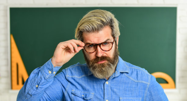 小学数学。戴眼镜的严厉老师。老师检查学生的知识。你准备好考试了吗?负责课堂辅导。使用数学工具和黑板。回到学校图片下载