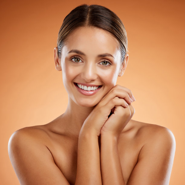美容，化妆和肖像护肤女性微笑，发光的皮肤和化妆品用于自我护理，身体护理或面部治疗。健康，自然和快乐的年轻女孩的脸在橙色的背景图片下载