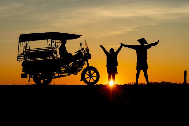 亚洲村庄的生活方式，一个泰国当地男性父亲和儿子的剪影，他们的天空实验室出租车在黎明日出时分的淡水湖旁，非常美丽的风景图片下载