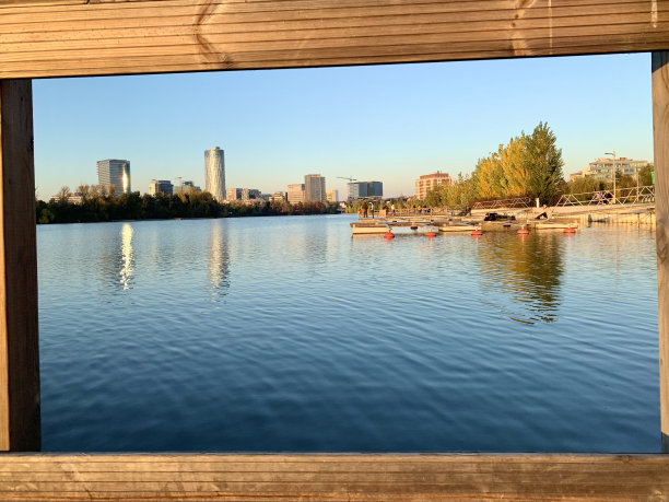 城市摩天大楼在公园湖中的倒影图片下载