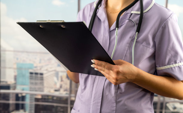 年轻护士在医院记录病人病情的剪裁肖像。图片下载