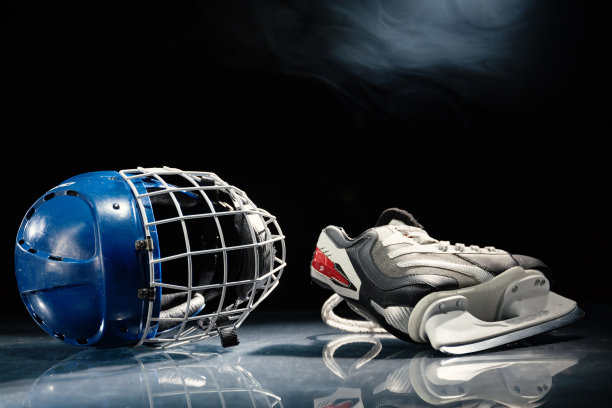 靠近曲棍球头盔和曲棍球冰鞋躺在反射表面。图片下载