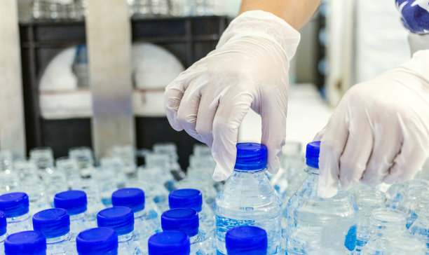 质检员的手水装瓶线处理和装瓶纯饮用水图片下载