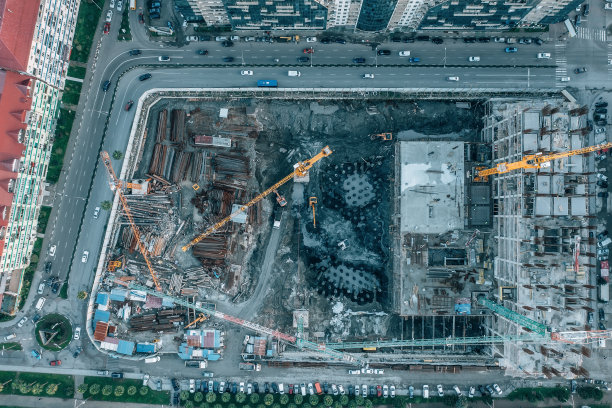 从无人机鸟瞰建筑工地。塔式起重机及工业机械，房屋开发图片下载