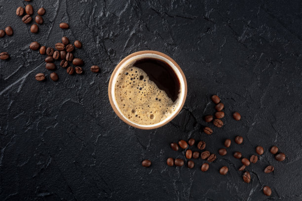 咖啡杯和豆子，顶部拍摄在一个黑暗的背景与复制空间图片下载