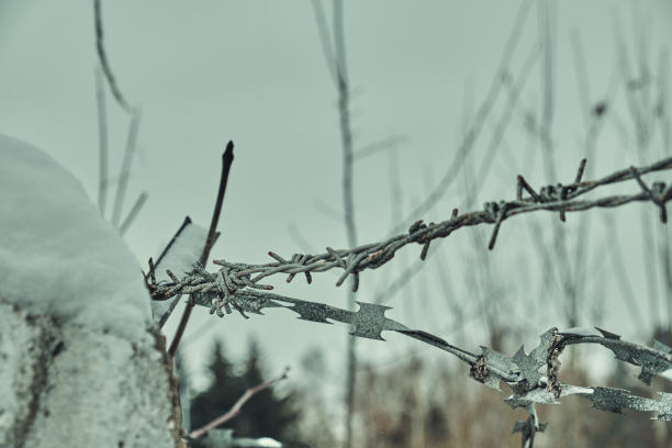 混凝土栅栏上的旧铁丝网，冬天的雪很大特写选择性聚焦图片下载