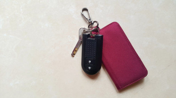 汽车钥匙遥控器与红色帆布钱包在大理石花岗岩背景图片下载