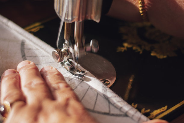 女士用缝纫机缝面料边图片下载