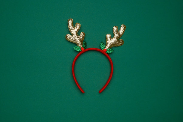 新年头饰的布局:绿色背景上的鹿角。俯视图图片下载