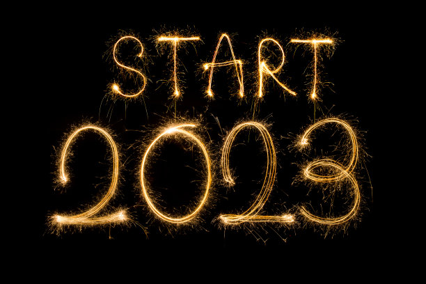 2023年新年快乐。闪闪发光燃烧文字2023年新年快乐孤立在黑色背景。美丽发光的金色叠加对象设计节日贺卡图片下载