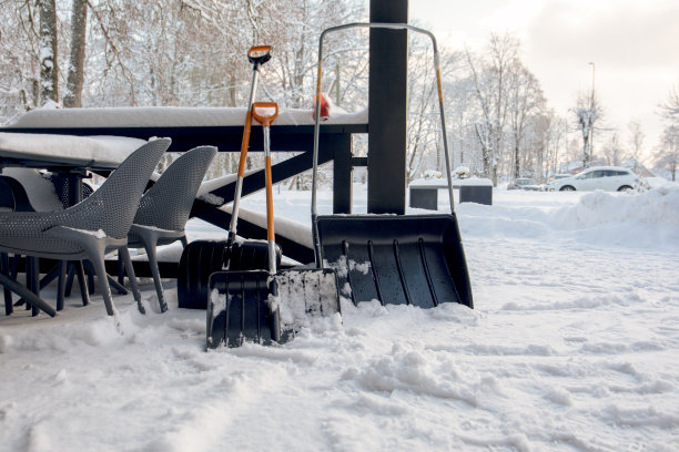 雪铲被放置在露台上。雪堆和暴风雪图片下载