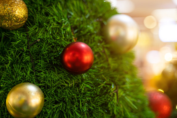 圣诞快乐，近距离彩色球，礼品盒和圣诞祝福图片包裹装饰在绿色圣诞树背景装饰在圣诞节和新年。图片下载