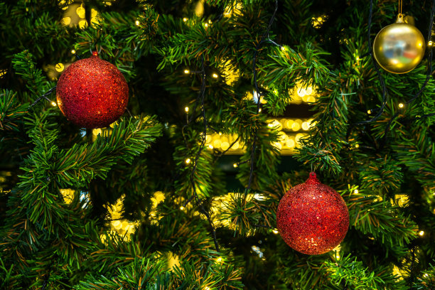 圣诞快乐，近距离彩色球，礼品盒和圣诞祝福图片包裹装饰在绿色圣诞树背景装饰在圣诞节和新年。图片下载