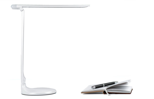 在桌面LED灯下用笔打开一本日记本图片下载