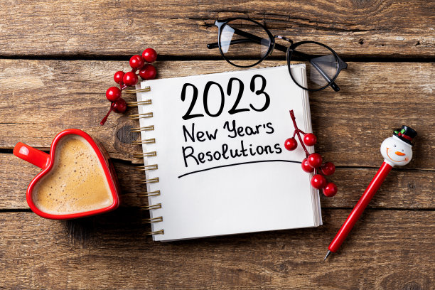 2023年的新年决心在桌子上。2023决心清单，笔记本，咖啡杯，桌子上的装饰品。目标，决心，计划，行动概念。2023年新年背景图片下载