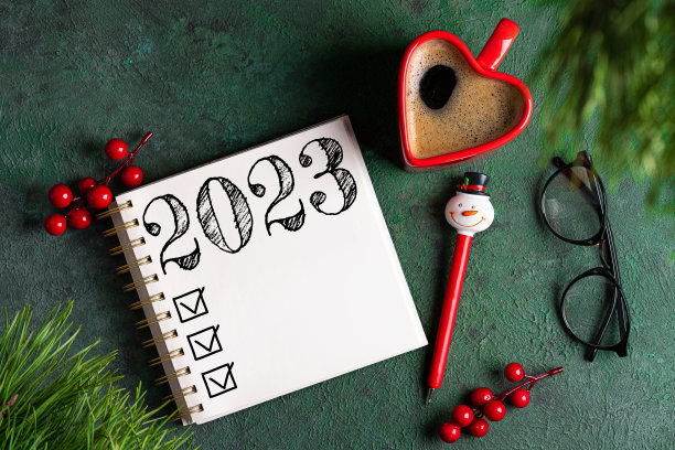 2023年的新年决心在桌子上。2023决心清单，笔记本，咖啡杯，桌子上的装饰品。目标，决心，计划，行动概念。2023年新年背景图片下载