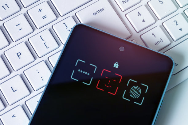 锁在电脑键盘上的手机。黑客企图，黑客攻击。IT安全系统，个人数据保护图片下载