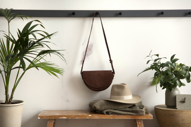 舒适的入口，木制长凳，咖啡桌，包衣架和个人配件的时尚构成。米色墙。家居装饰。模板。图片下载