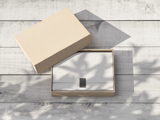 打开纸板礼盒模型与白色包装纸和贴纸在户外的白色木桌图片下载