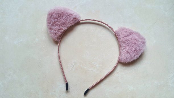 粉红色的猫耳朵头带在大理石花岗岩背景图片下载