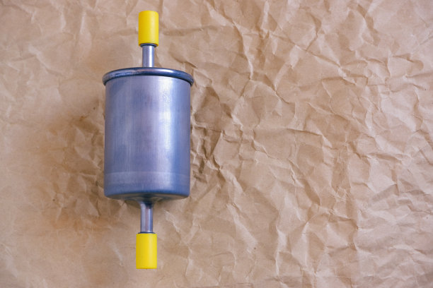 汽车零部件。汽车燃油汽油滤清器。滤镜在牛皮纸上的特写照片。图片下载