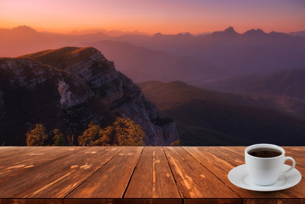 咖啡杯放在木桌上，可以看到美丽的自然背景图片下载