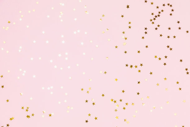 金色闪光的五彩纸屑星星在粉红色粉彩的背景。闪光，闪耀，明亮。圣诞喜庆平铺，寒假，新年，生日快乐概念。平铺，俯视图，复制空间。图片下载