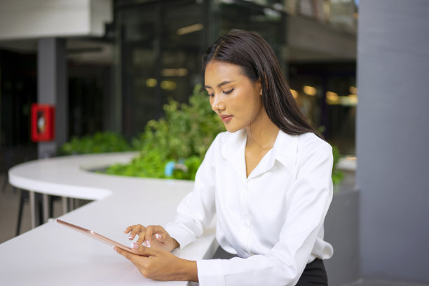年轻女子正在公共场所网上学习。图片下载