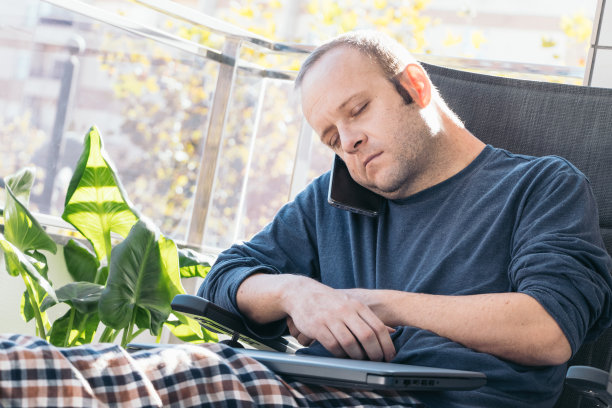 在自家阳台上工作的年轻人睡着了图片下载