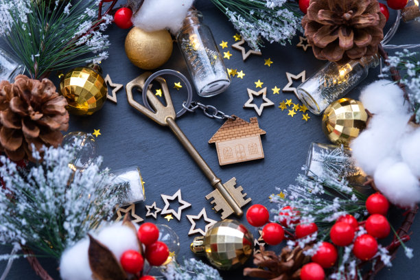 钥匙的房子与钥匙链的黑色背景与圣诞装饰布局。新年礼物，圣诞节礼物。建筑，设计，工程，搬新房，抵押，租赁和购买房地产图片下载