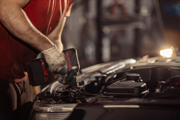 一名男性汽车修理工在汽车服务中用扳手拧下螺栓图片下载