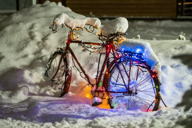 在雪地里骑自行车在街上。这辆自行车是为新年装饰的图片下载