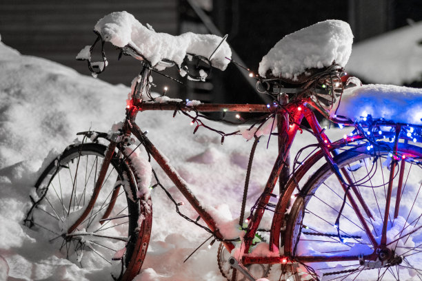 在雪地里骑自行车在街上。这辆自行车是为新年装饰的图片下载
