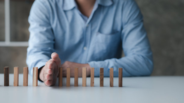 一个商人拿着一排木块的特写镜头，木块与商业风险管理的对比。风险管理的概念。副本的空间。图片下载