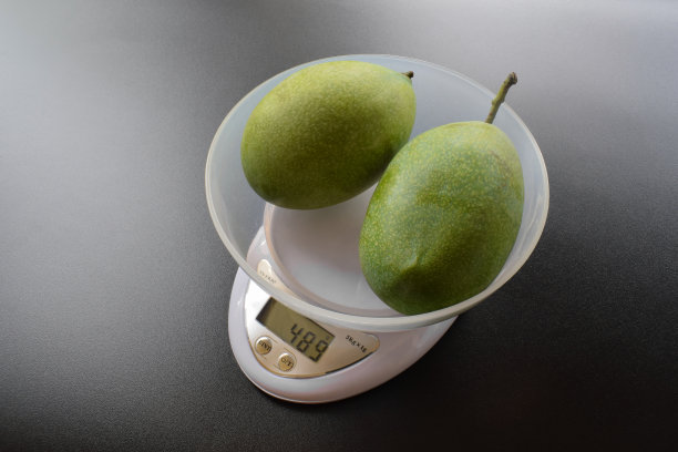 数字厨房秤上的芒果水果图片下载