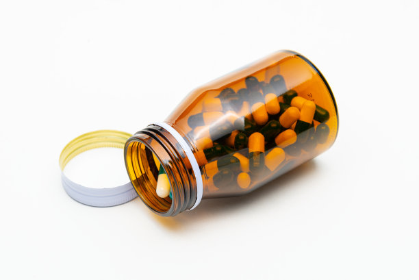 琥珀玻璃瓶和药丸隔离在白色。图片下载